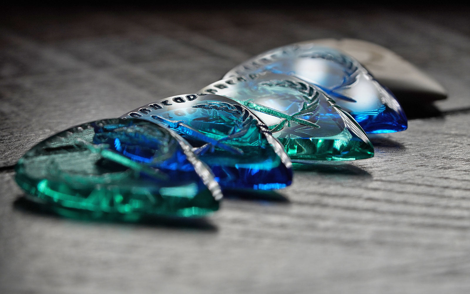 Translucent acrylic guitar picks in blue and green by Iron Age Guitar Accessories