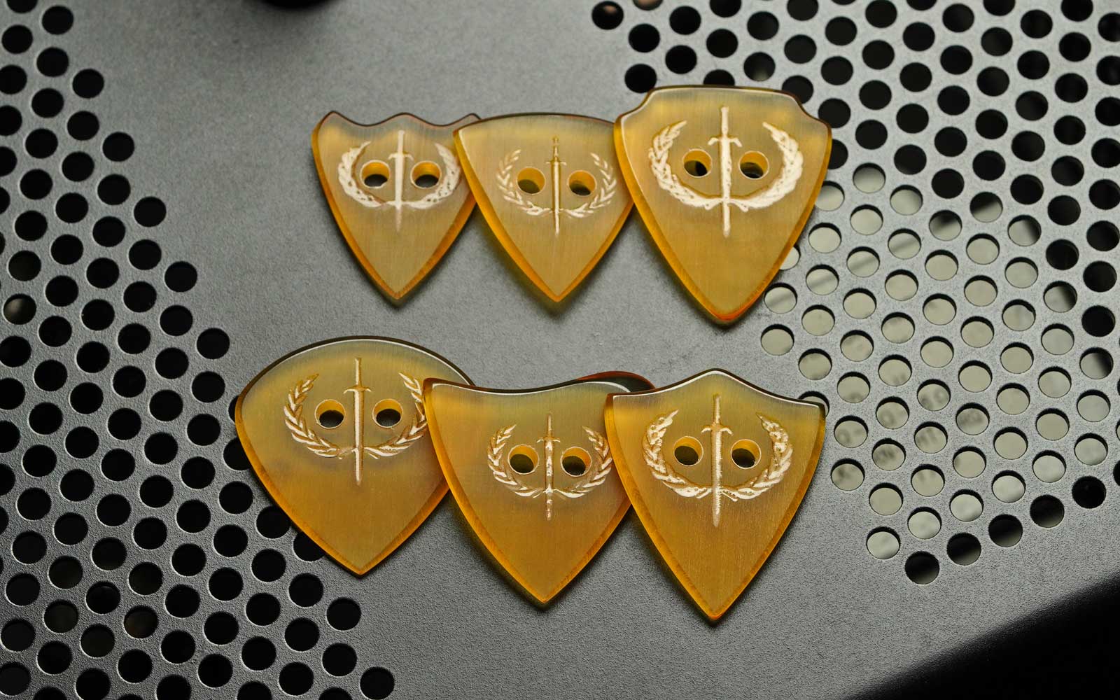 Six Gladiator Ultem guitar picks arranged in two rows on an MT-15 amp head.