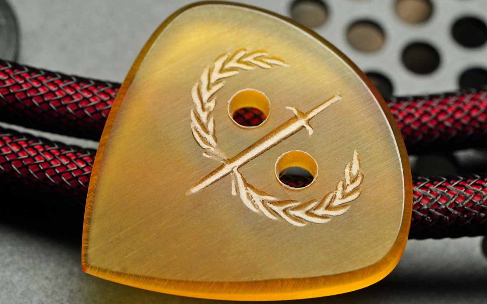 Iron Age Secutor Ultem guitar pick with engraved surface and grip holes