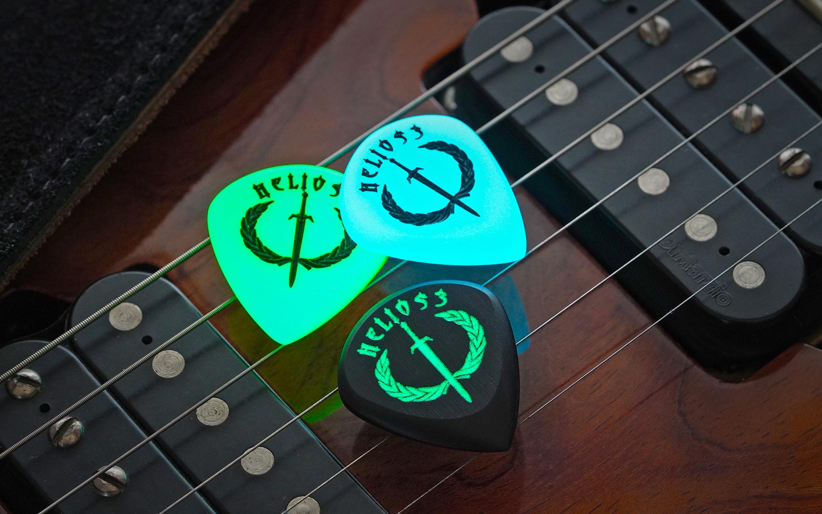 Three Iron Age Jazz style guitar picks displayed on an electric guitar