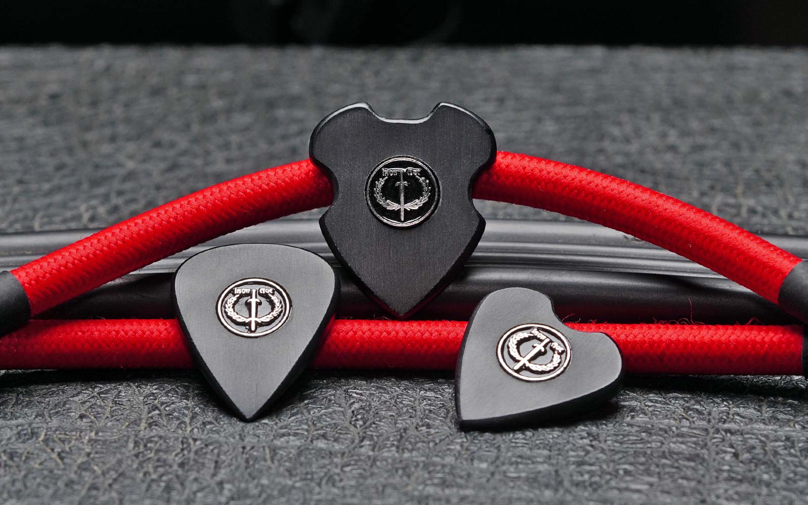 Legio Ferrata Centurion, Spearhead and Pugio guitar picks on an amp with red patch cables.