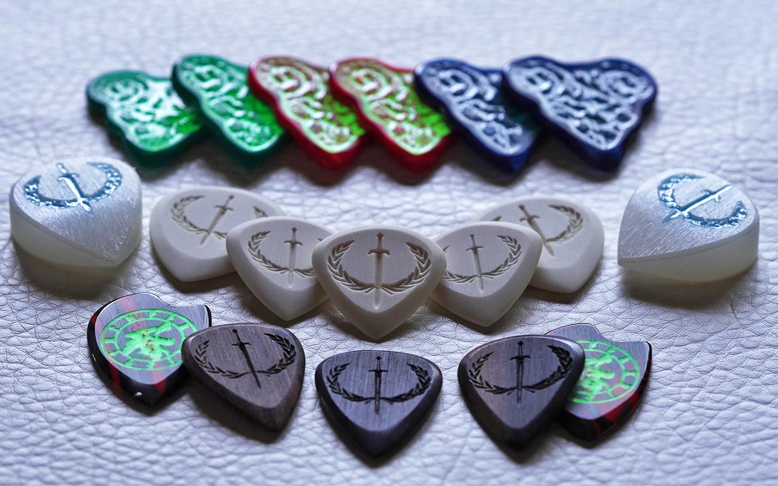 Thick Iron Age guitar picks in multiple shapes and sizes with a 4mm Jazz-style pick in focus