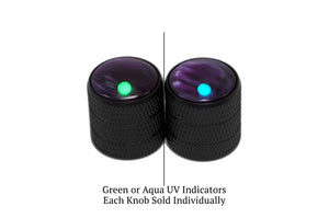 Two black knobs with green and blue UV indicators on a white background