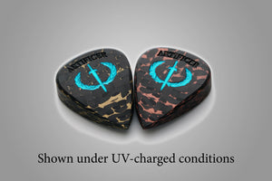 Artificer carbon fiber guitar picks with aqua Sword and Laurel logos glowing after UV charging
