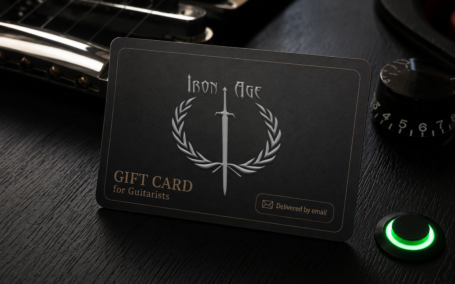Iron Age gift card for guitarists displayed with electric guitar hardware and a green LED killswitch