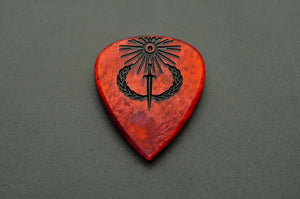 Sol Invictus red resin guitar pick shown flat with black sun, sword, and laurel engraving