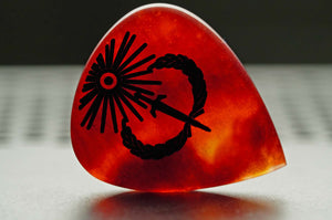 Backlit Sol Invictus red resin plectrum standing on its side to show translucent material depth