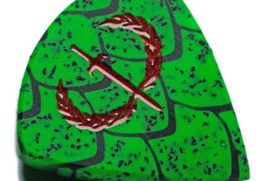 Close-up detail of Wyvern Edition Dragon Scale guitar pick with red pearl Sword and Laurel engraving